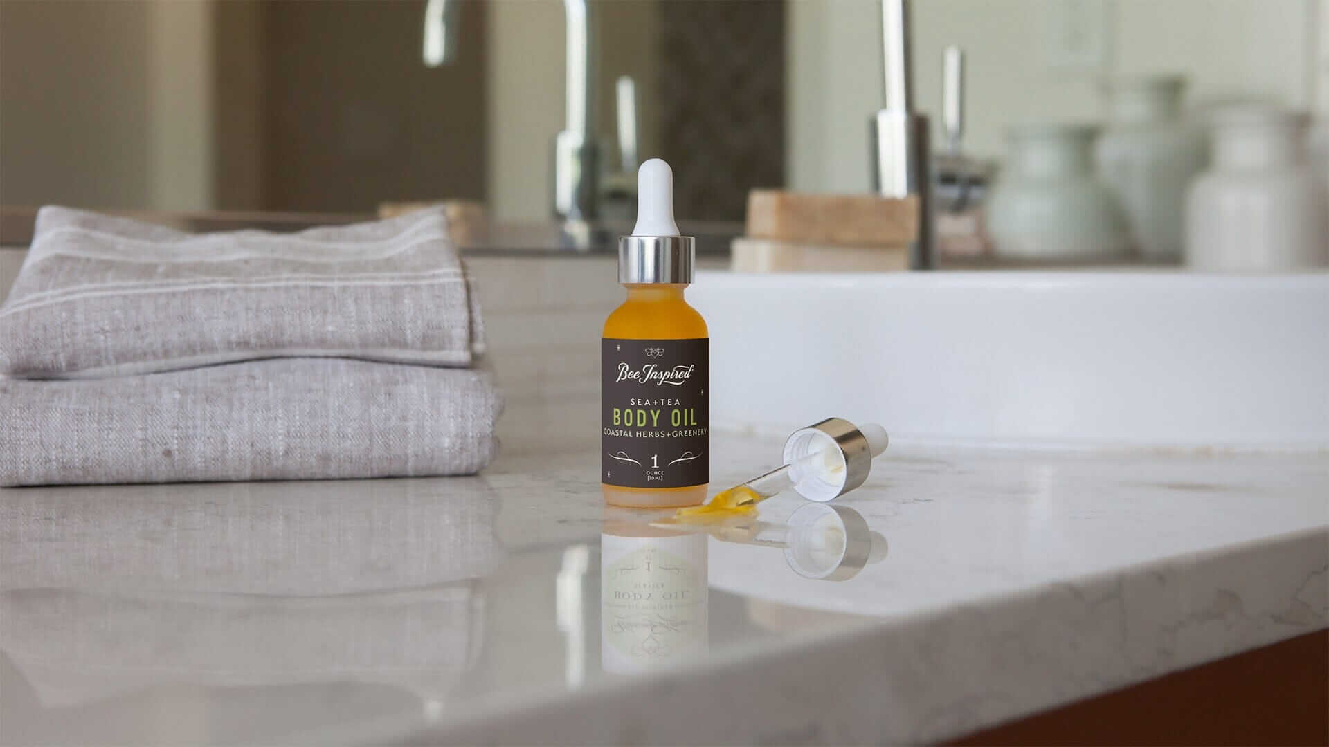 a jar of body oil sits on a marble bathroom counter