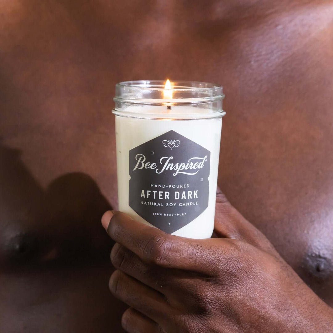 a man holds an After Dark jelly jar candle against his chest