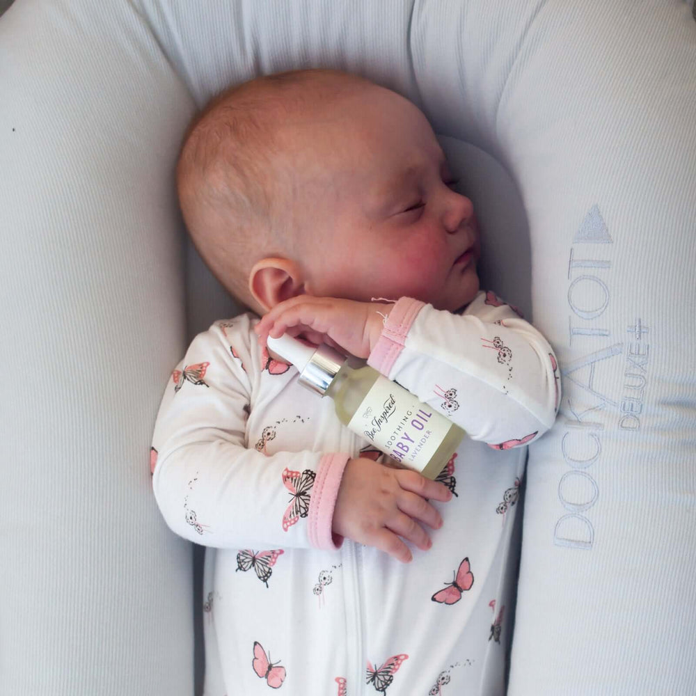 sleeping baby holding lavender baby oil