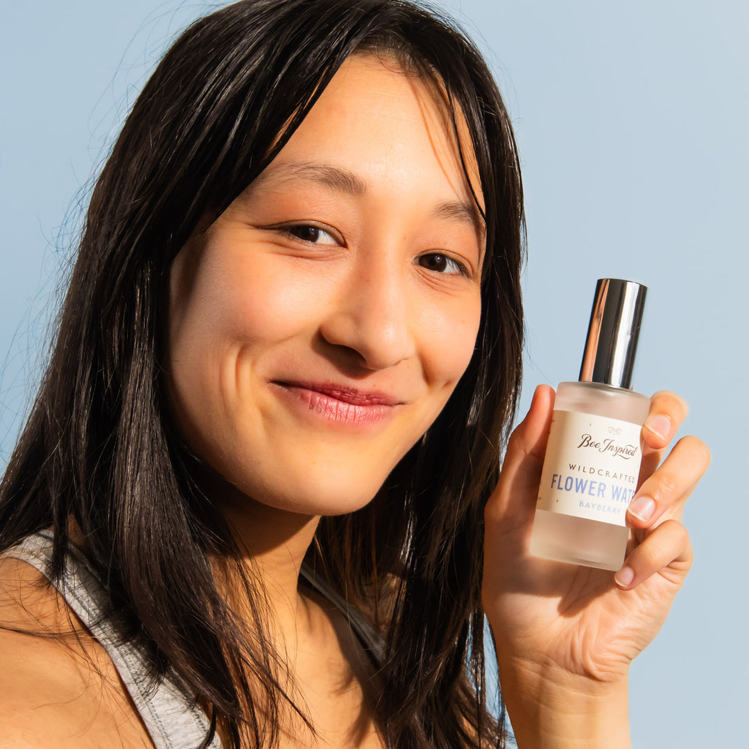 woman smiling and holding bayberry leaf flower water