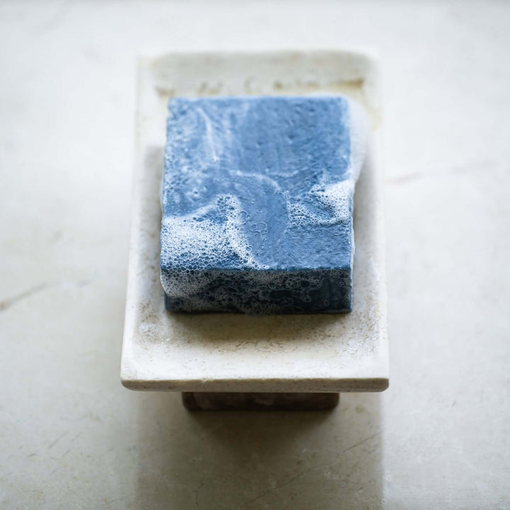 Black clay bar soap on soap tray
