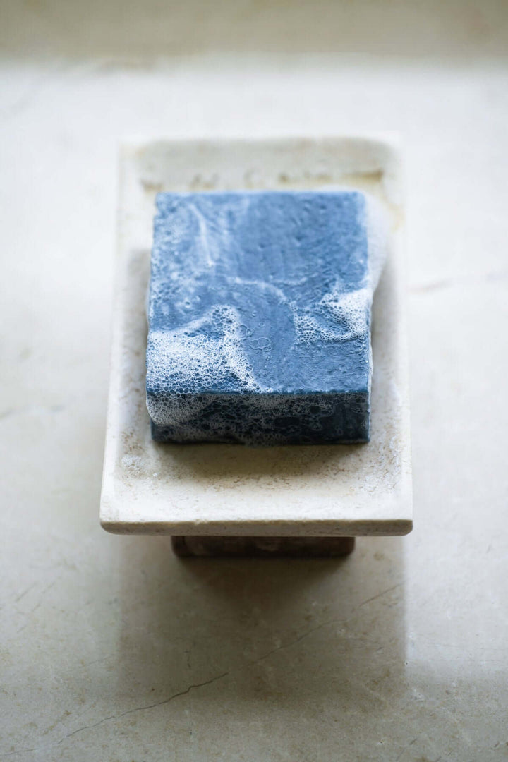 Black clay bar soap on soap tray
