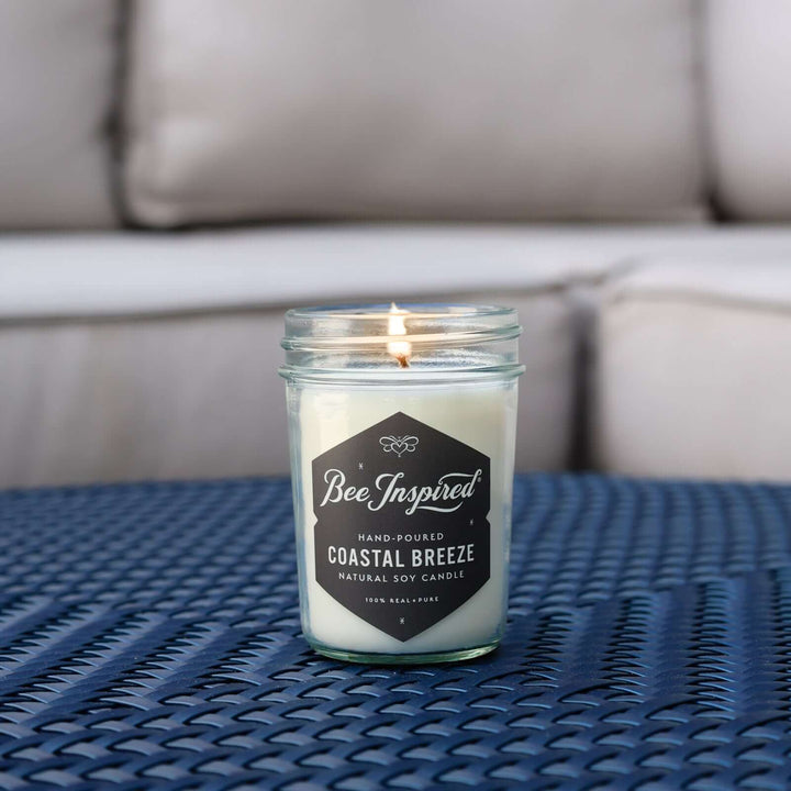 Coastal Breeze jelly jar candle burning on blue table