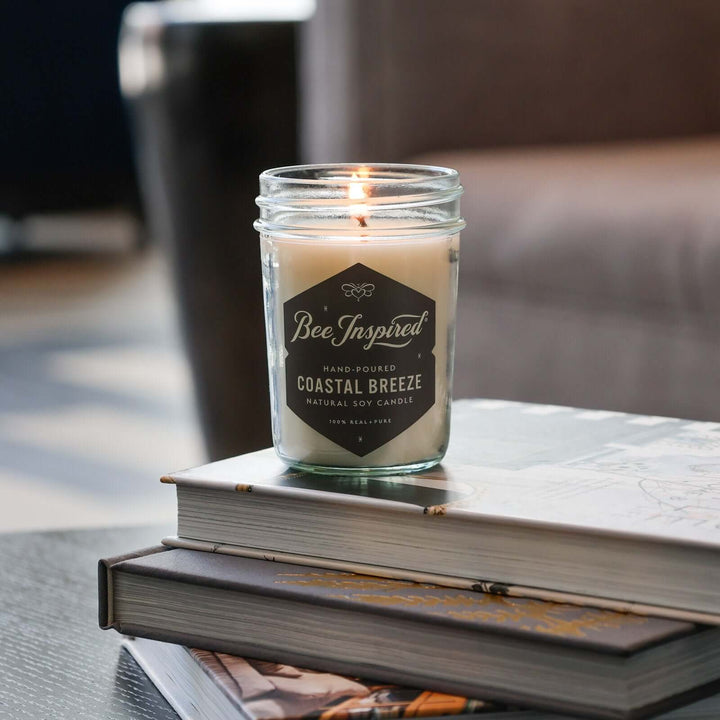 Coastal Breeze jelly jar candle burning on stack of books
