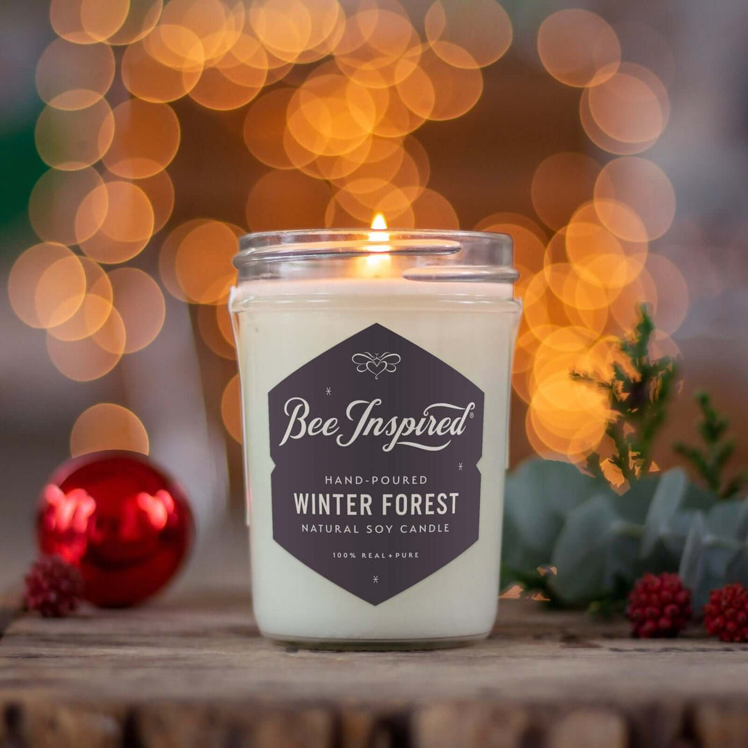 Winter Forest jelly jar candle burning next to holiday decorations and lights