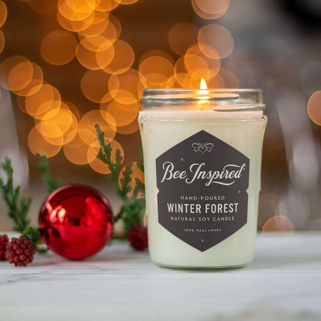 Winter Forest jelly jar candle burning next to holiday decorations and lights