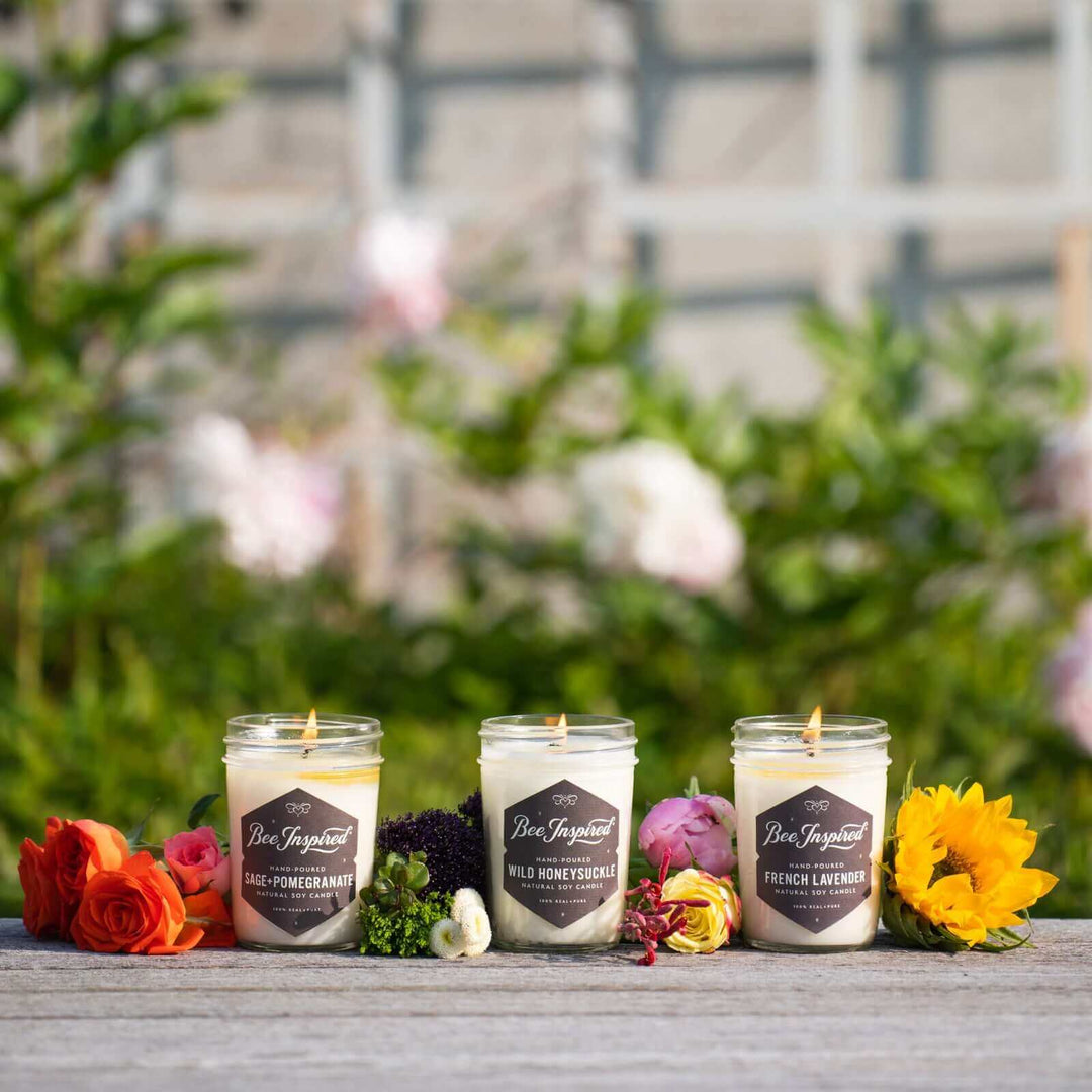 Garden jelly jar candle set burning next to flowers