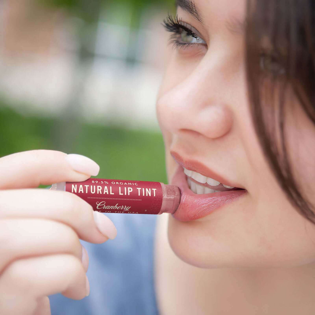 Woman applies Cranberry lip tint