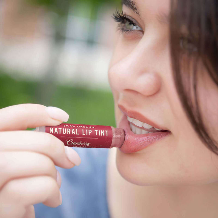 Woman applies Cranberry lip tint