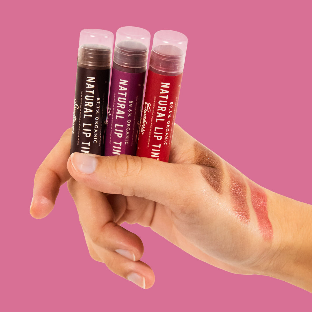 holding Bold lip tint trio with colors tested on hand