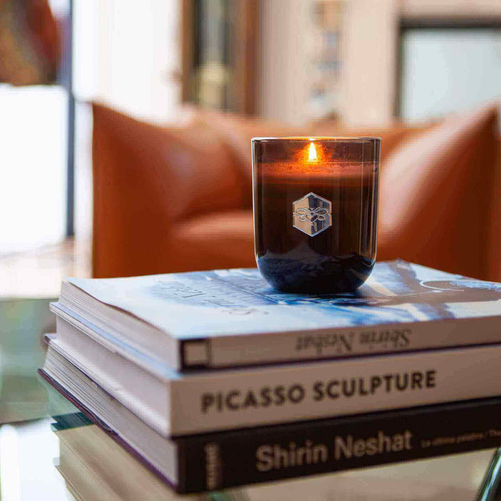 Luxe candle burning on stack of books
