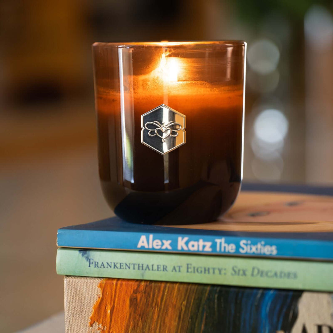 Luxe candle burning on stack of books