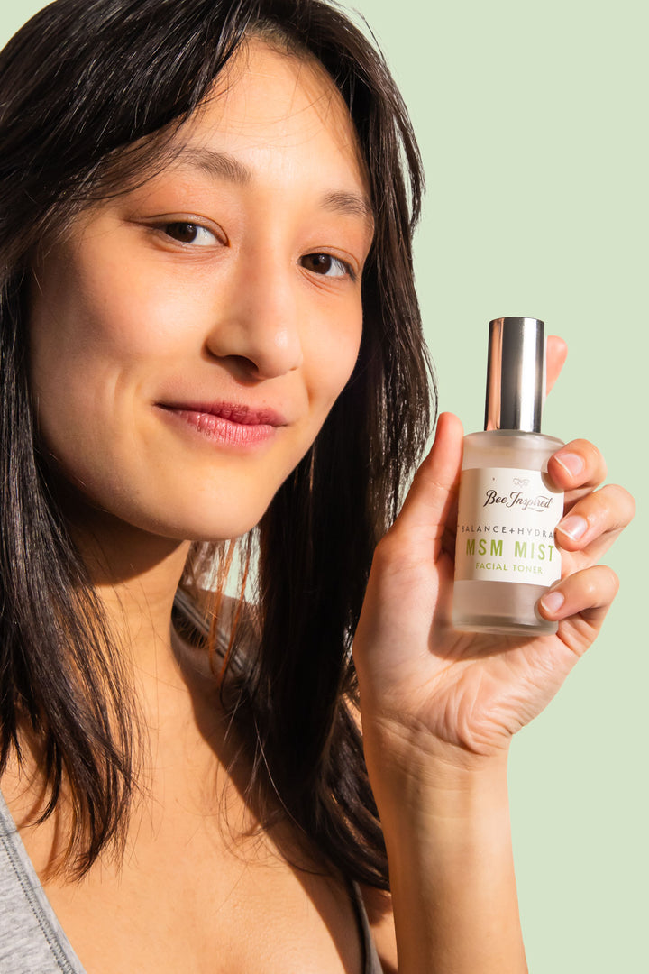 woman smiling and holding msm mist facial toner