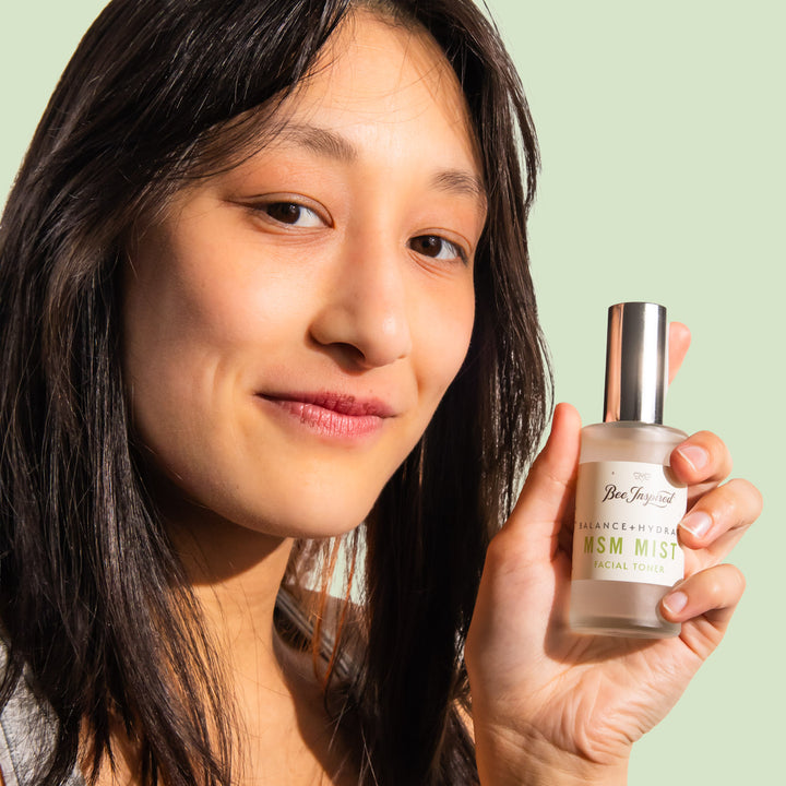 woman smiling and holding msm mist facial toner