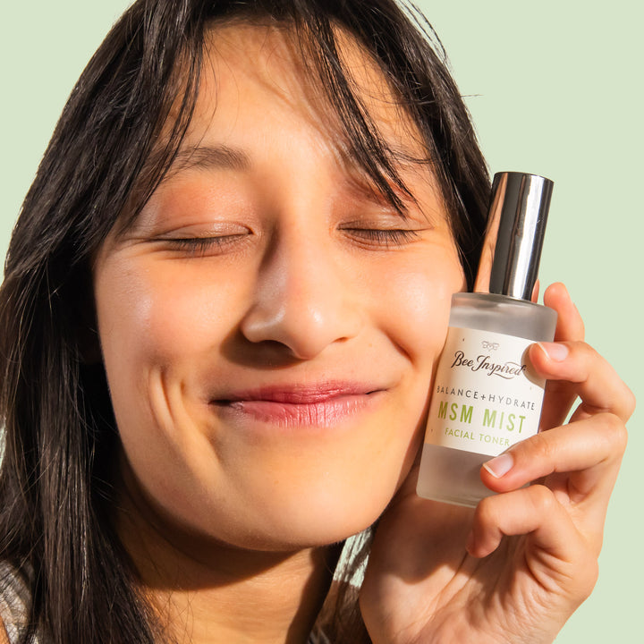 woman smiling and holding msm mist facial toner