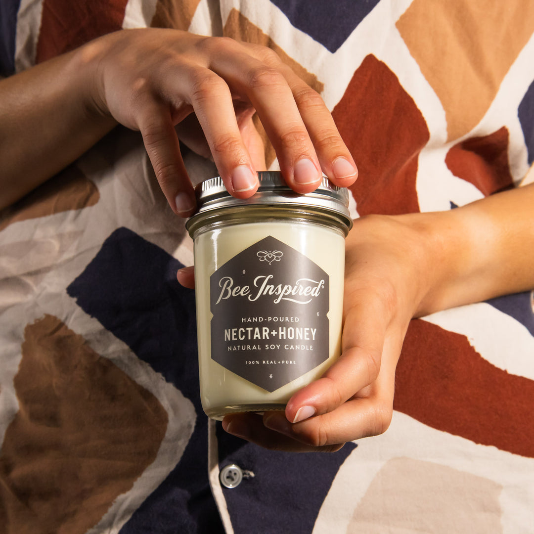 hands holding a nectar and honey soy candle