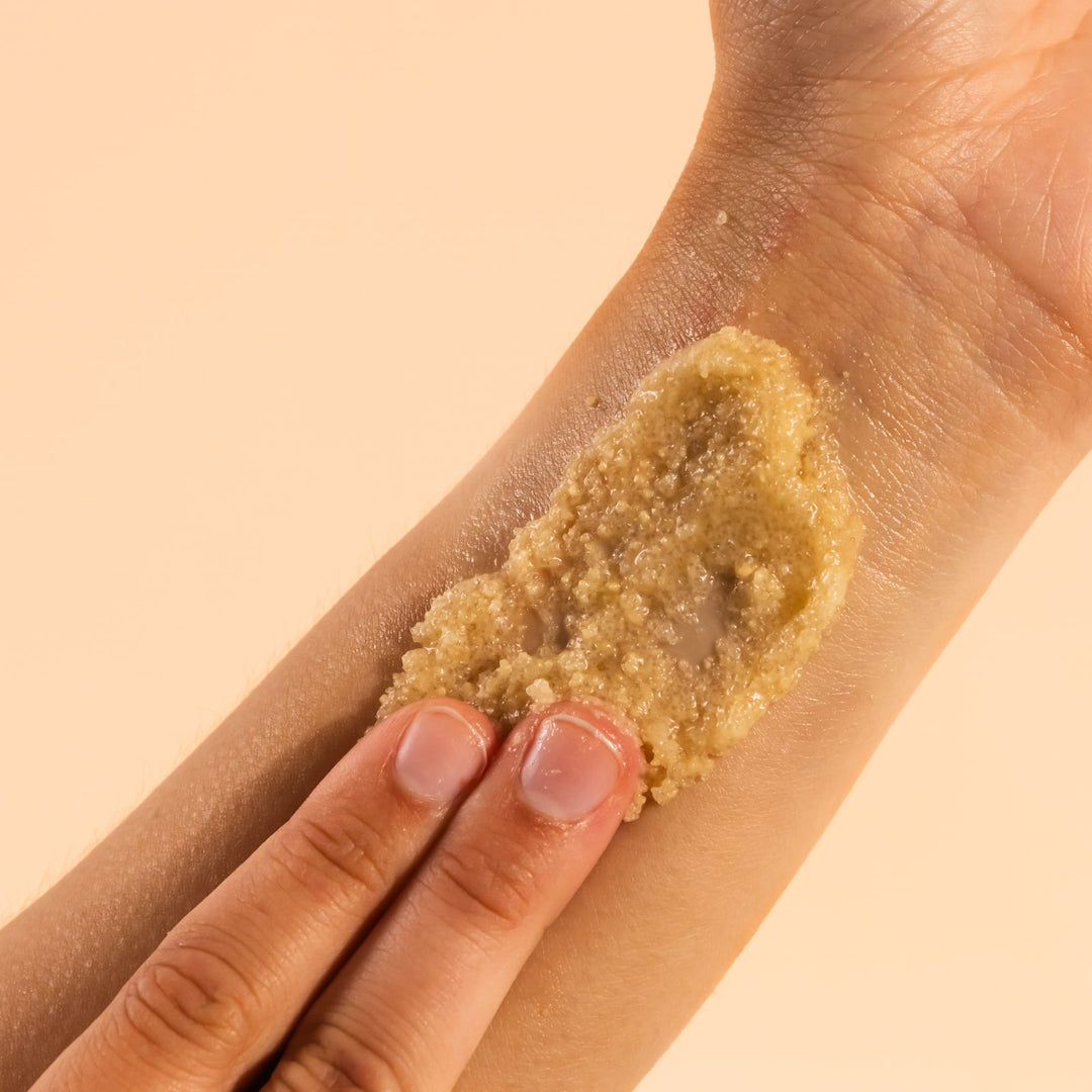 hand scrubbing nectar and honey body scrub onto arm