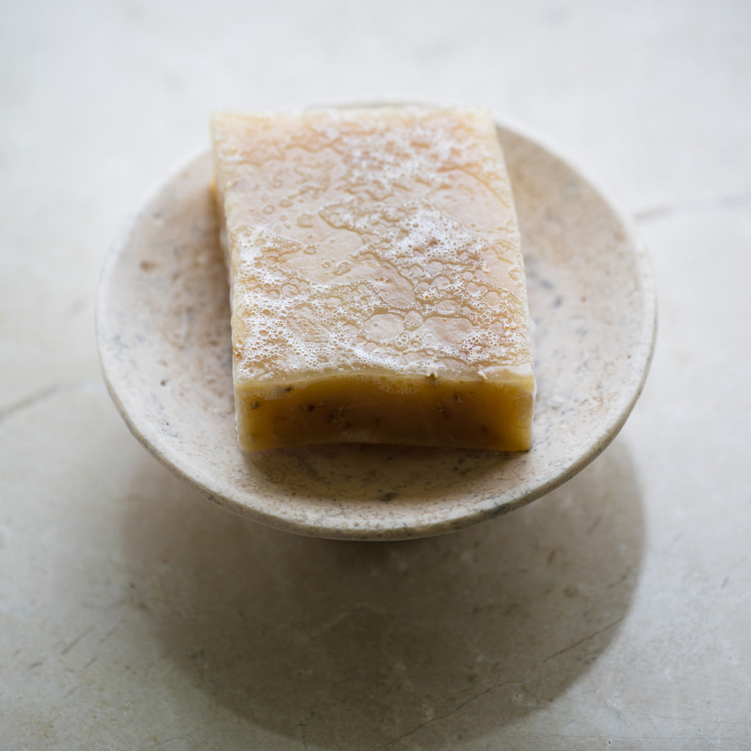 bee inspired oatmeal + lavender bar soap in a soap dish