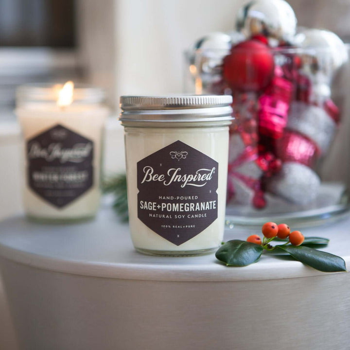 Sage+Pomegranate and Winter Forest jelly jar candles in front of decorative ornaments