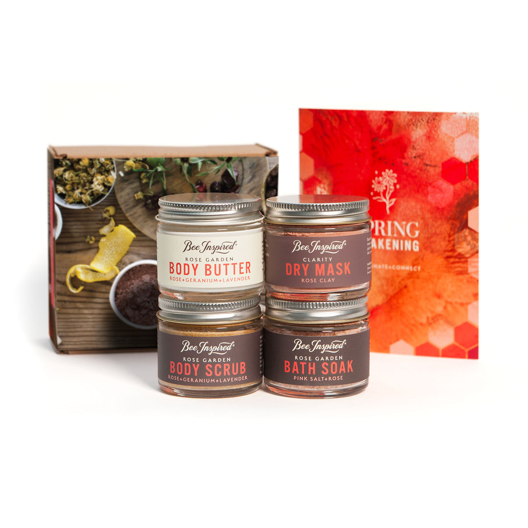 Set of body care products in the Petite Spring Awakening Set including body butter, scrub, mask, and soak with a branded box on a white background.