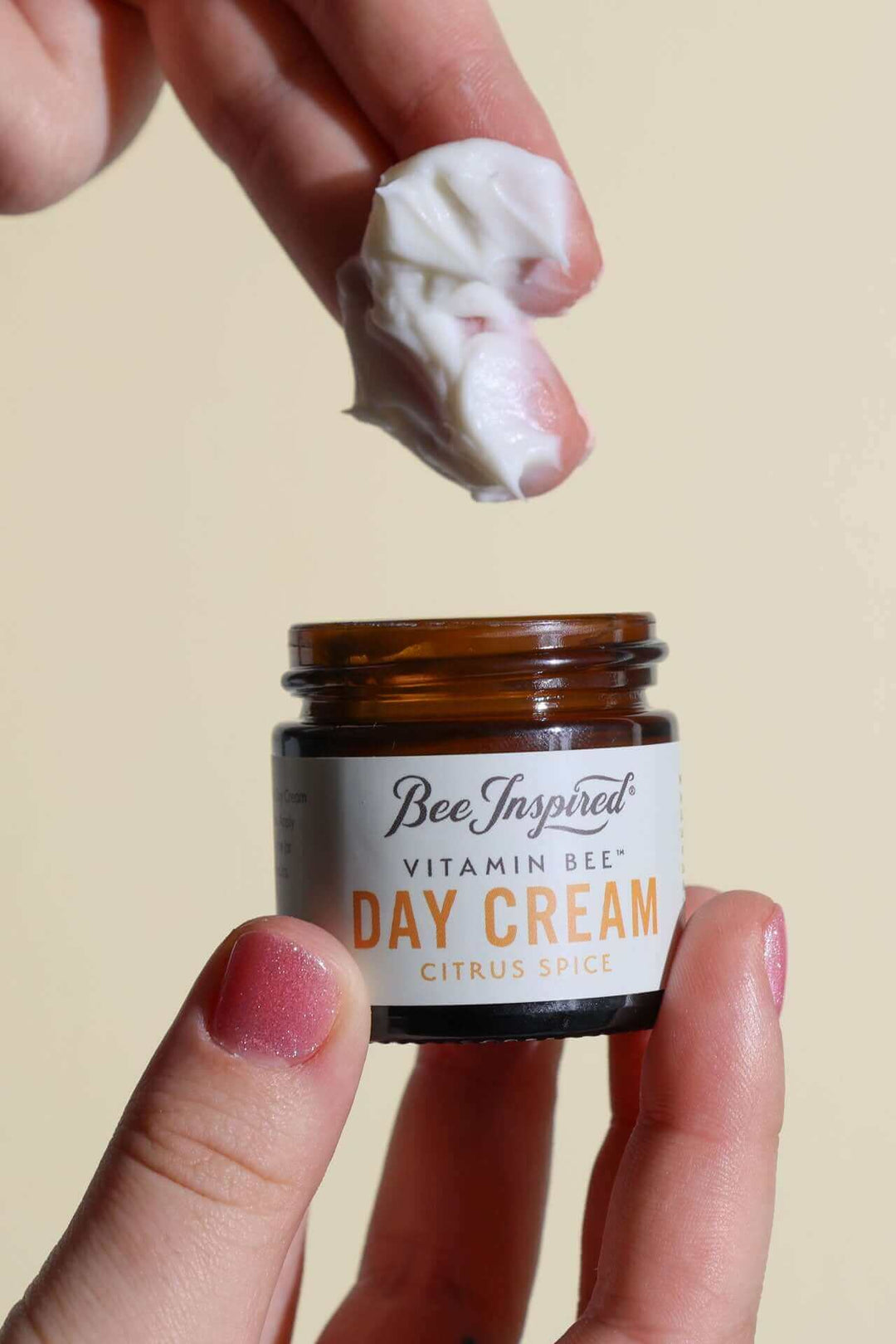 Taking Vitamin Bee citrus spice day cream from the jar