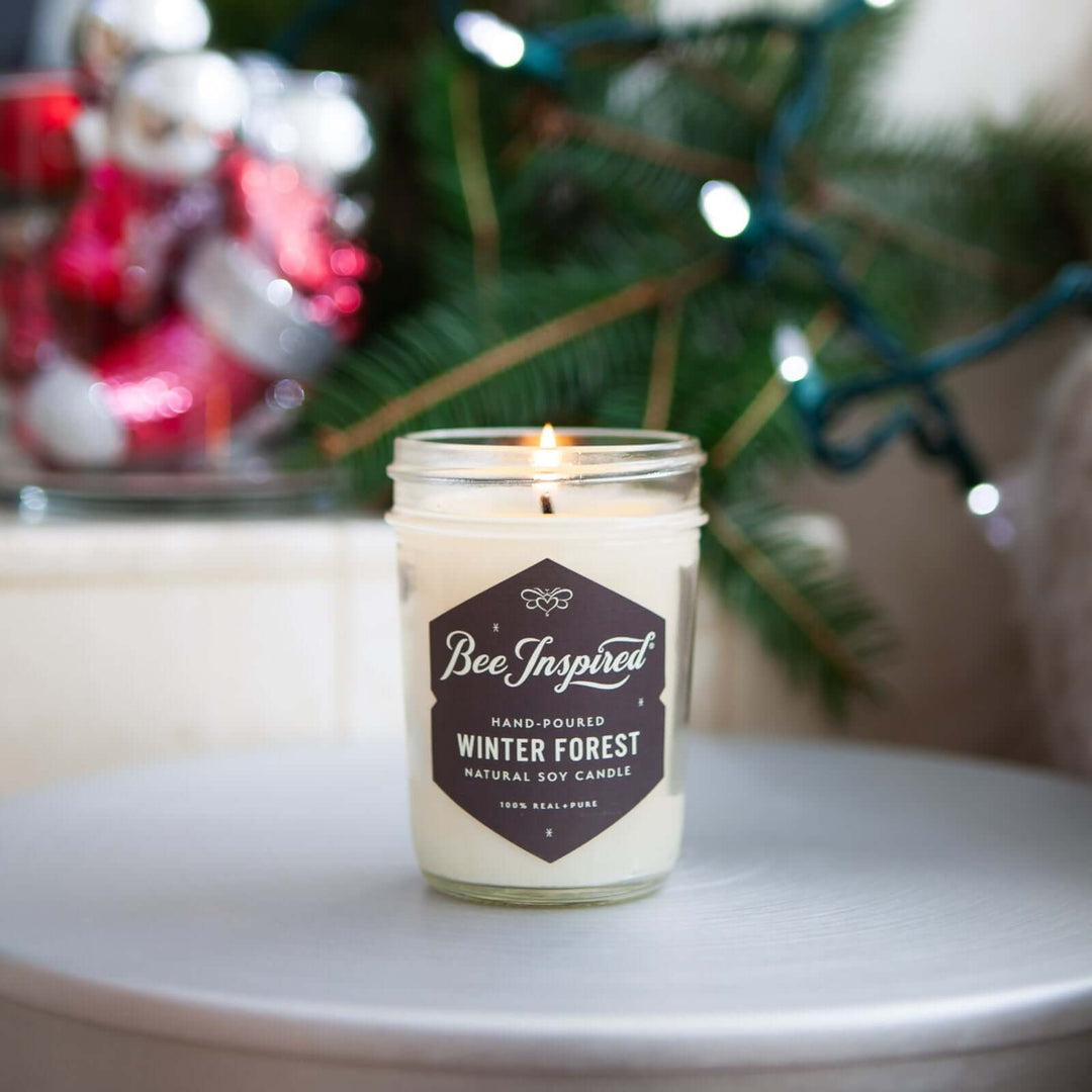 Winter Forest jelly jar candle burning next to holiday decorations