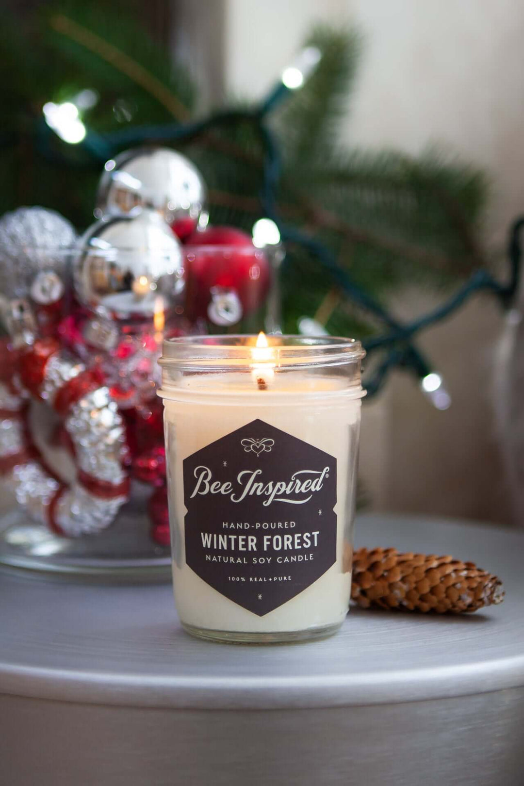 Winter Forest jelly jar candle burning next to holiday decorations
