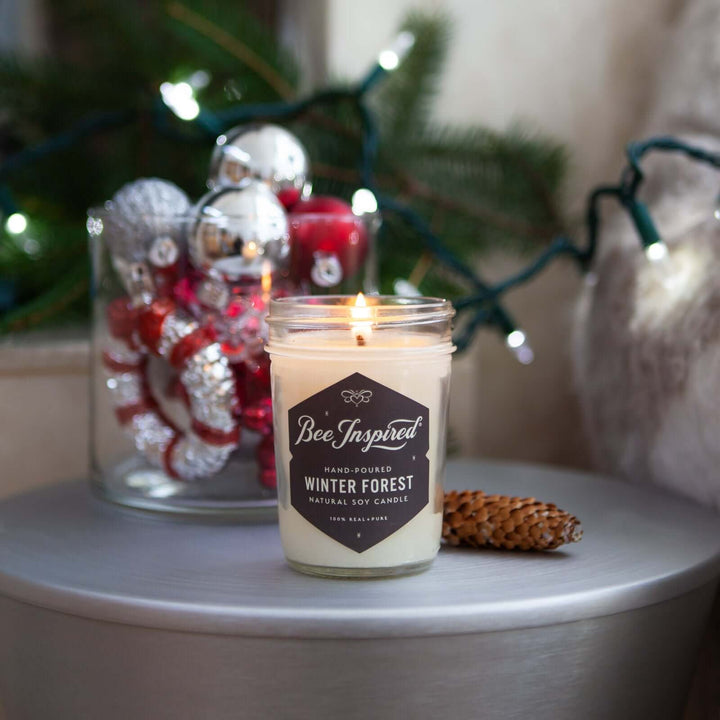 Winter Forest jelly jar candle burning next to holiday decorations