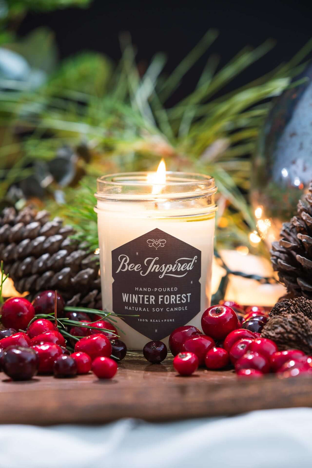 Winter Forest jelly jar candle burning next to holiday decorations