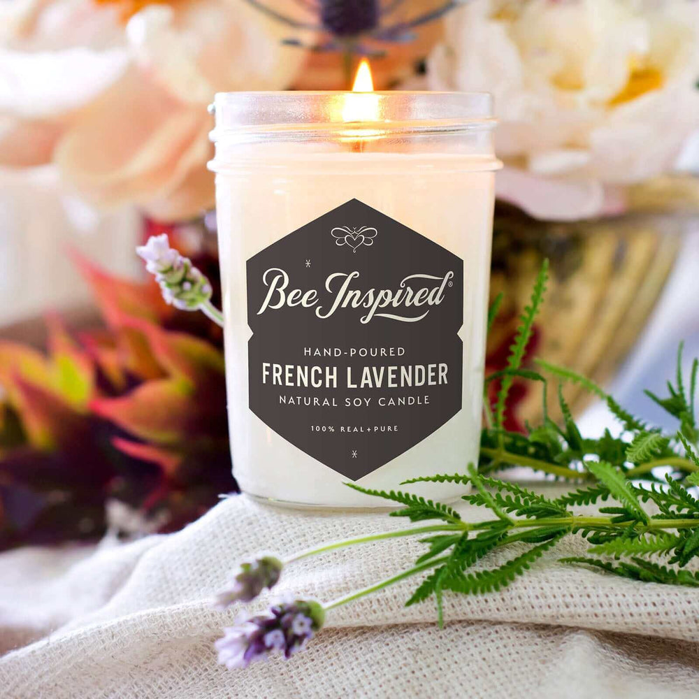 French Lavender jelly jar candle burning next to flowers and lavender
