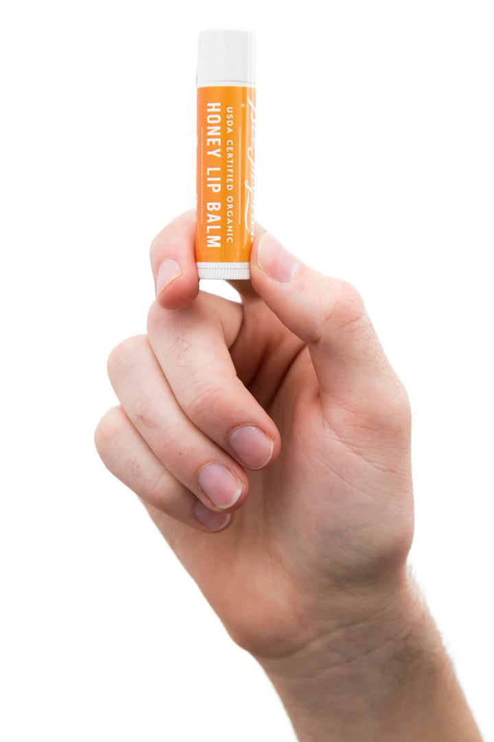 Holding honey lip balm in hand