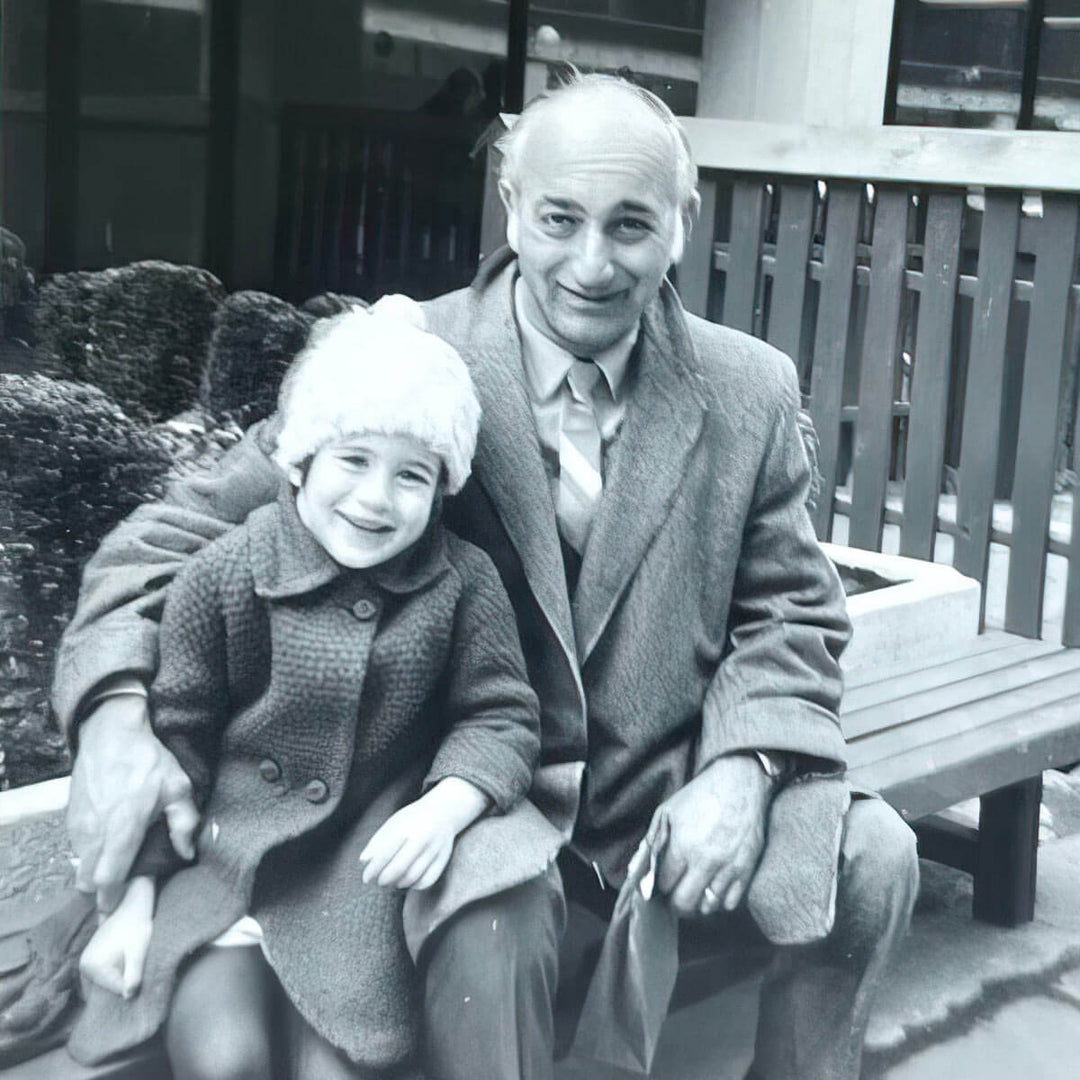 Black and white photo of Kara sitting on a park bench with her dad