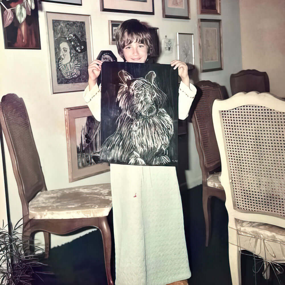 Young Kara holding a drawing of a dog in front of framed drawings