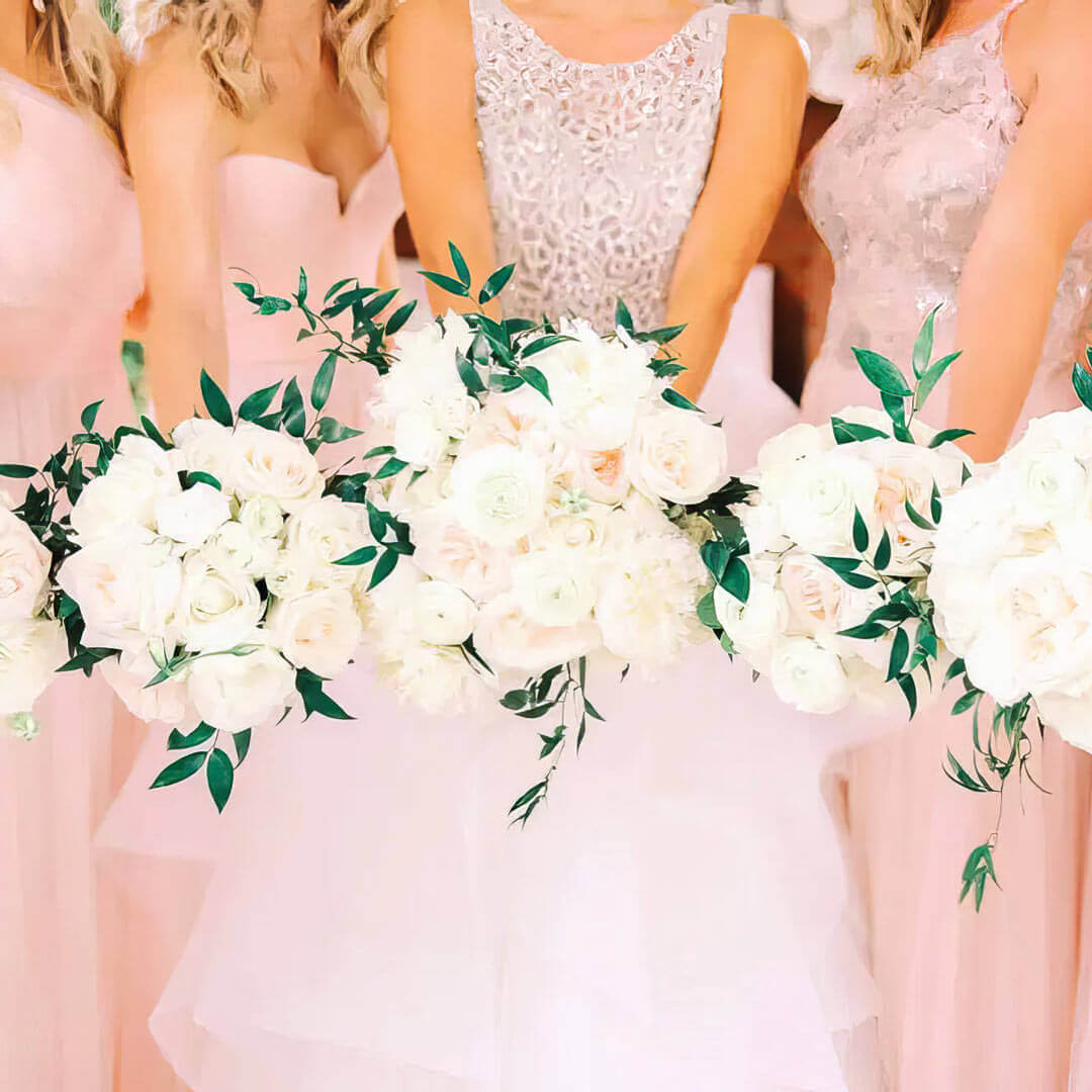 bridesmaids holding bouquets of white roses