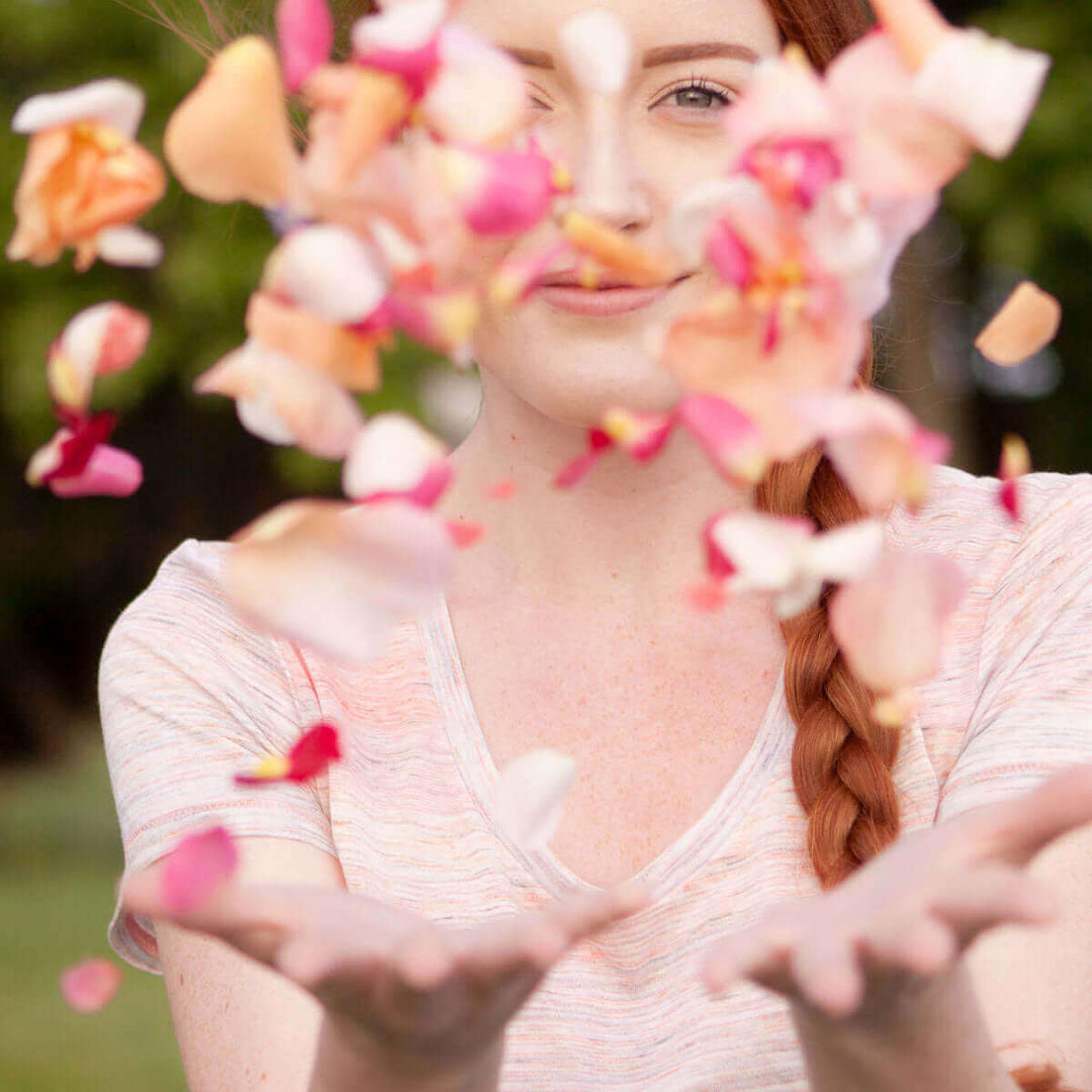 woman throwing rose petals into the air