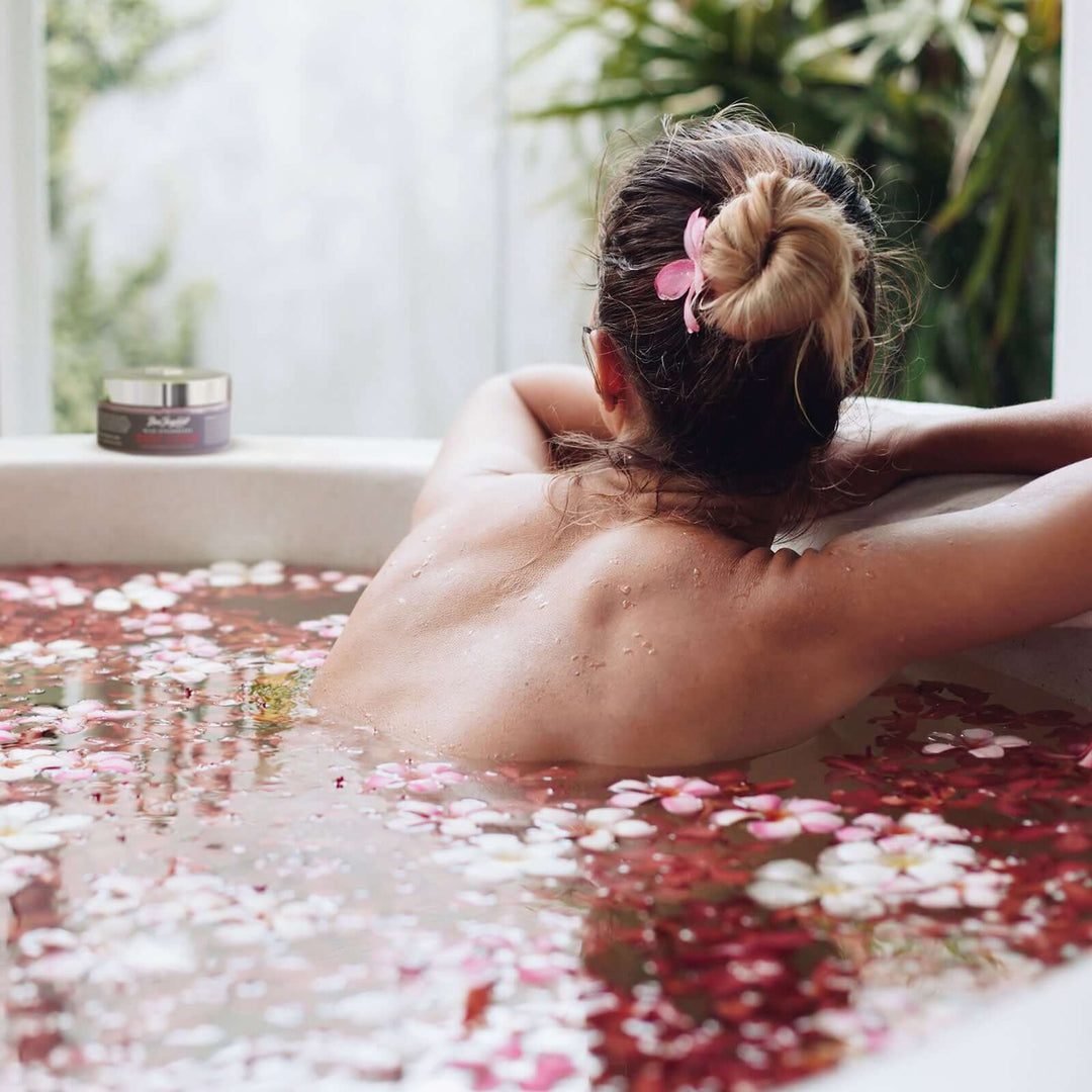 Woman soaking in a bath with flower petals