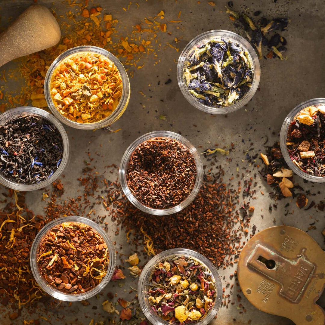 overhead shot of open jars of Bee Inspired tea with loose leaf tea scattered around