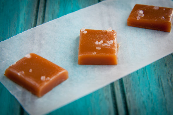 salted honey caramels wax paper on wood