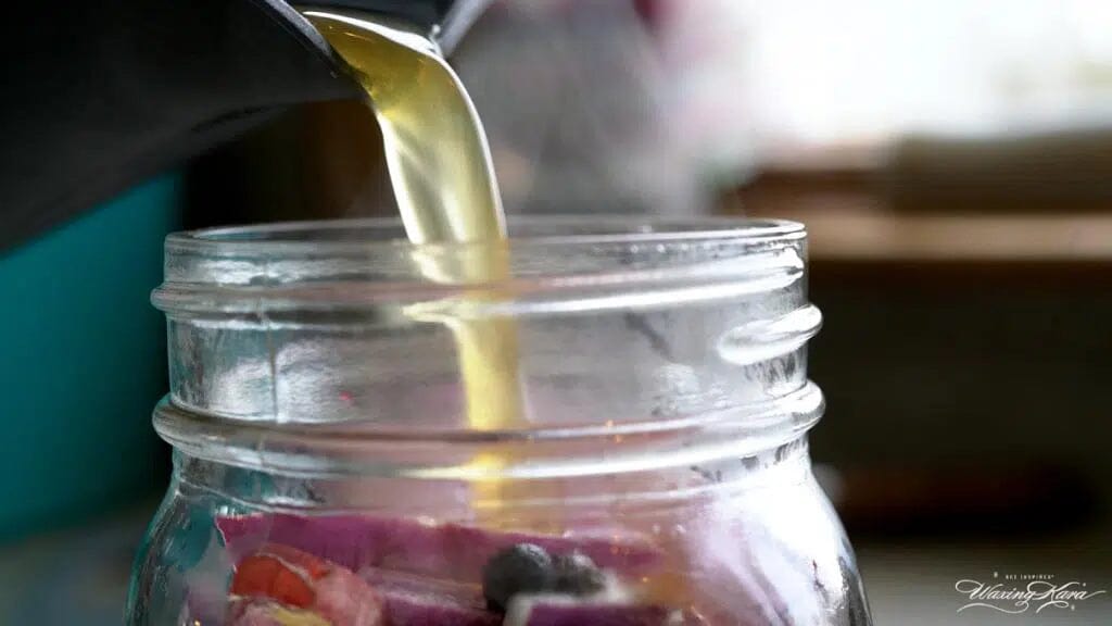 pouring pickling juice on onions in glass jar