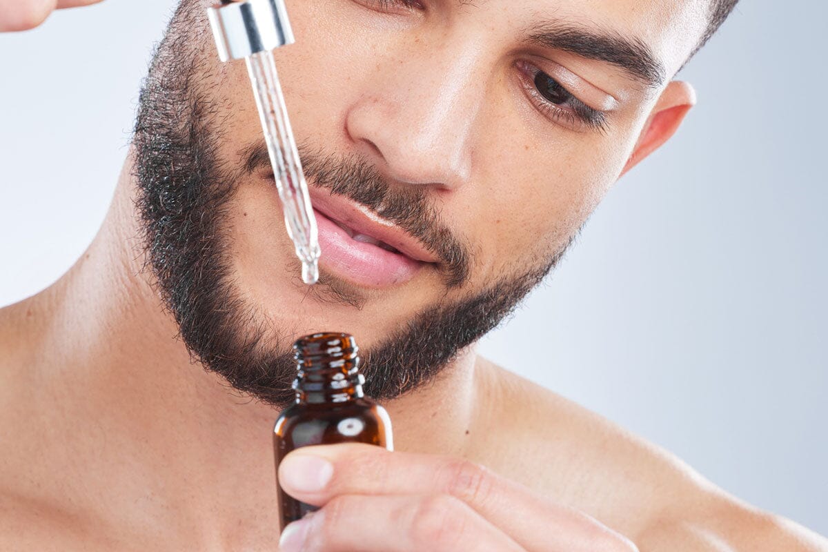 man examining beard oil in dropper
