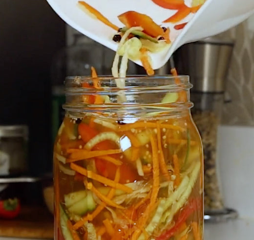 filling our pickling jar with pickling brine and various vegetables