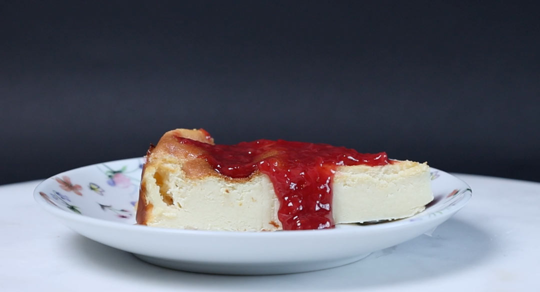 Slice of gluten-free high protein cheesecake with homemade strawberry jam on top