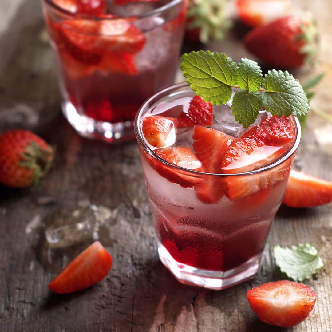 sparkling strawberry lemonade garnished with fresh strawberries and mint leaves.
