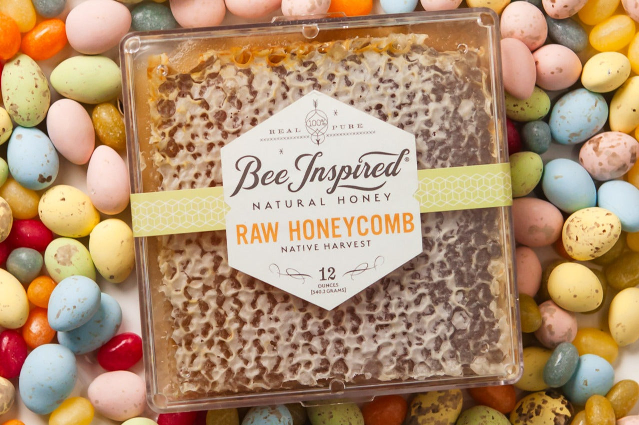 Packaged raw honeycomb with a visible brand label, surrounded by colorful Easter eggs.
