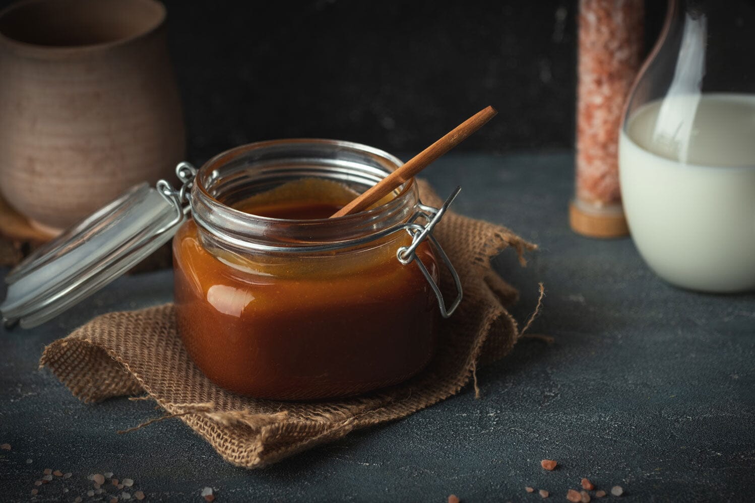 caramel sauce in tumbler with spoon