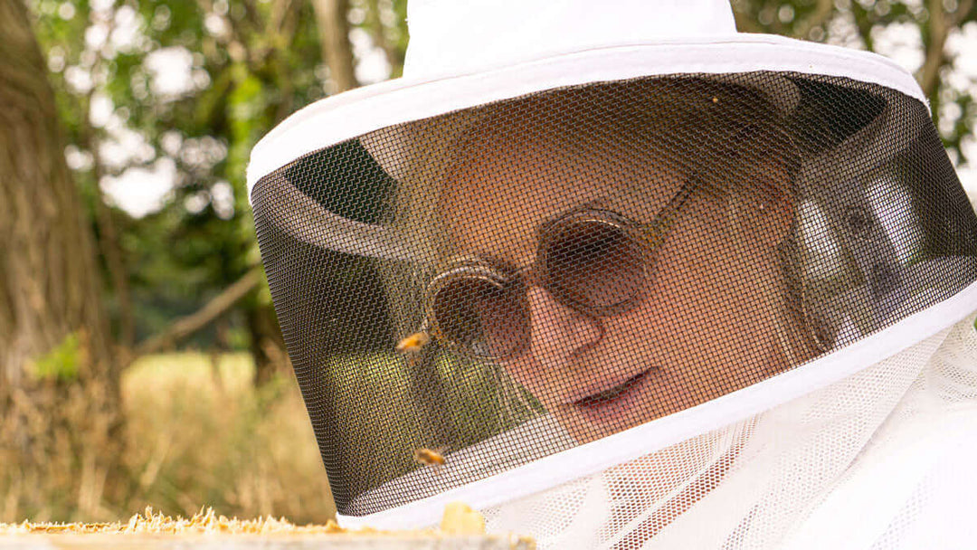 Kara in her beekeeping suit with bees at her chesterhaven beach farm