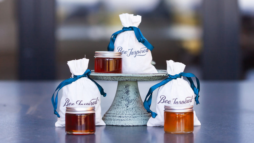 Mini honey party favor jars and bags set up on a counter top