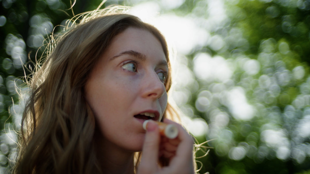 woman applies plastic-free honey lip balm