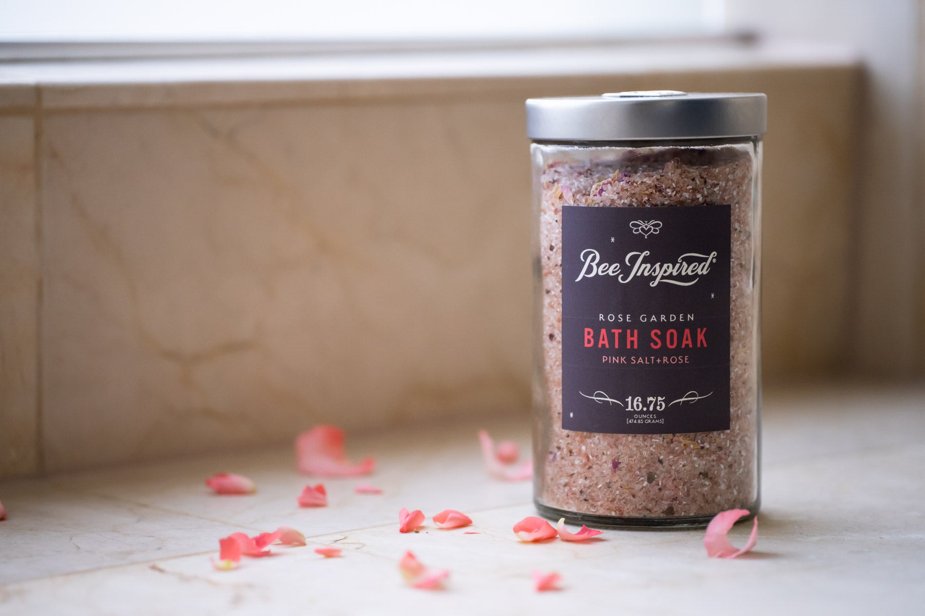 bee inspired rose garden bath soak in glass on a bathroom counter