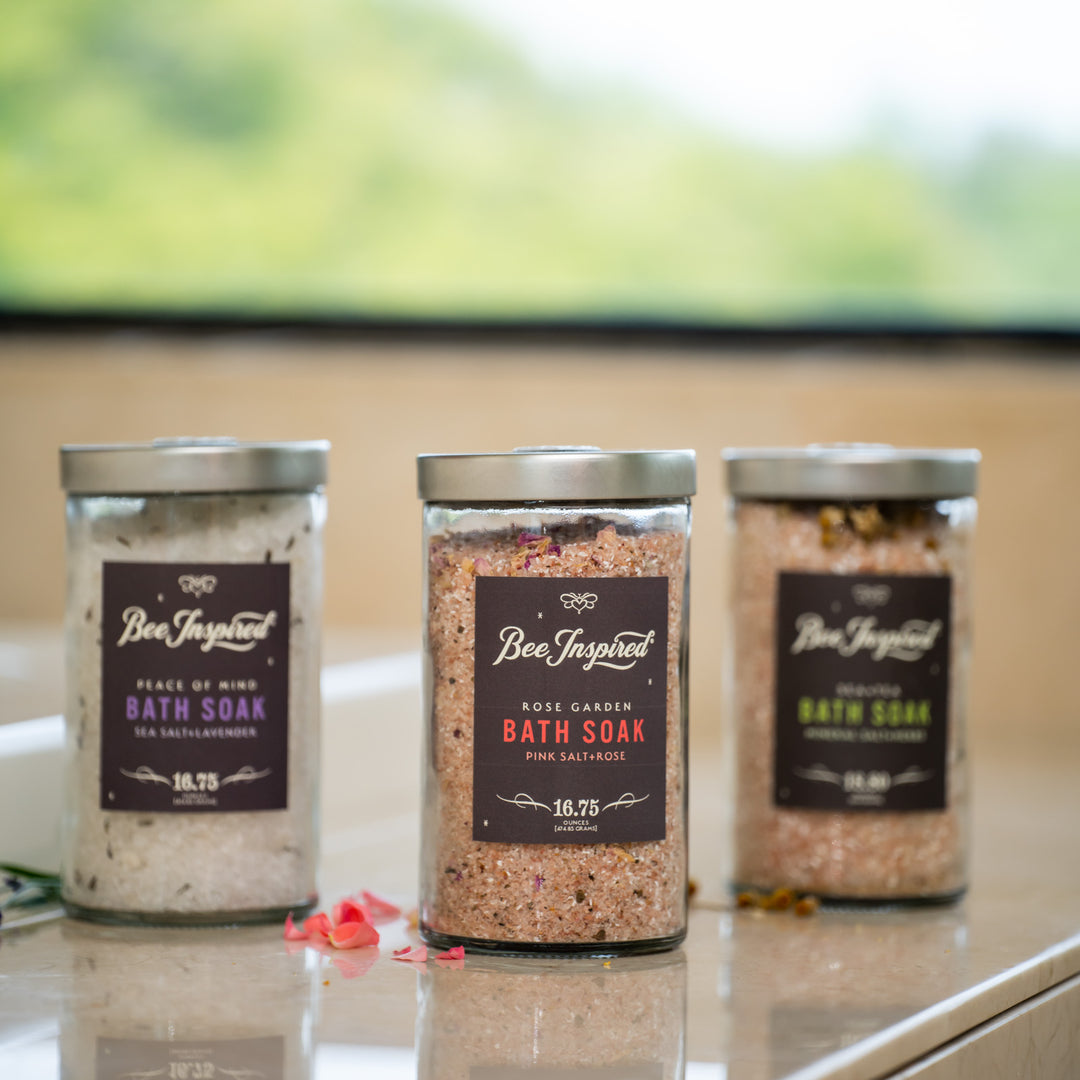 bee inspired bath soaks in glass collection on a bathroom counter